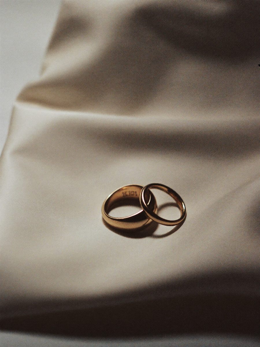 Two wedding rings resting on folded raw silk in soft window light.
